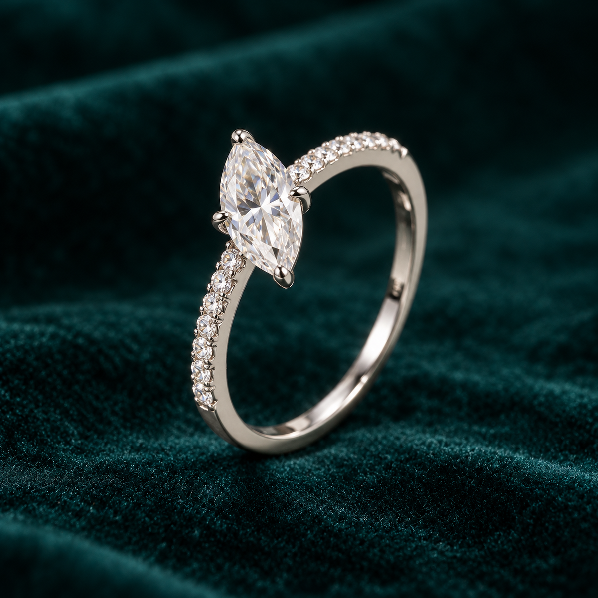 Alba Ring: sterling silver marquise moissanite solitaire ring with pave shoulders on teal velvet