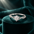 Corin Crown Ring: sterling silver ring with a round moissanite centre stone and a V-shaped crown halo on teal velvet