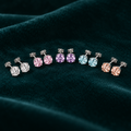 Daphne Stud Earrings: sterling silver four-claw stud earrings in five pastel colours on teal velvet