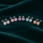 Daphne Stud Earrings: sterling silver four-claw stud earrings in five pastel colours on teal velvet