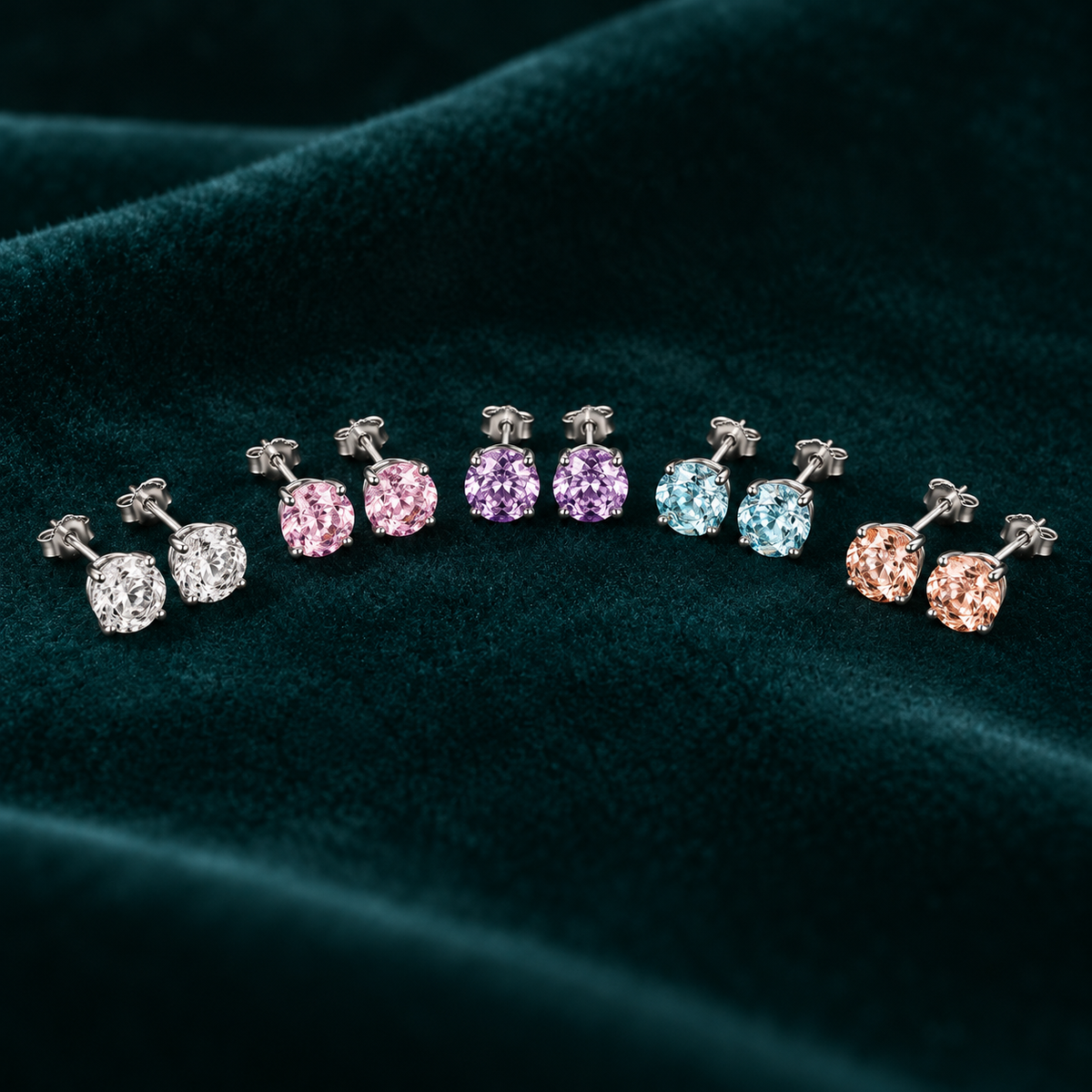 Daphne Stud Earrings: sterling silver four-claw stud earrings in five pastel colours on teal velvet