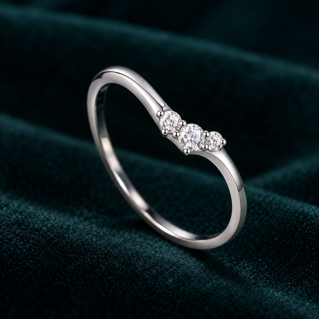 Dione Ring: thin sterling silver V-shaped ring with three small round moissanite stones on teal velvet