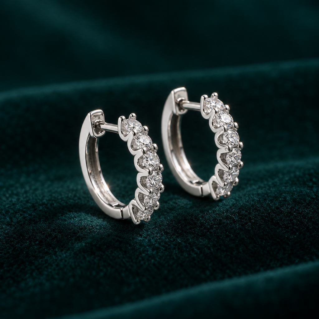 Genevieve Hoop Earrings: sterling silver huggie hoops with a row of claw-set round moissanite stones on teal velvet