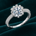 Mabel Halo Ring: sterling silver round moissanite ring in a scalloped flower halo with pave band on teal velvet