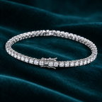 Vesper Tennis Bracelet: sterling silver tennis bracelet with a continuous line of round moissanite stones on teal velvet