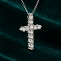 Viviane Cross Necklace: sterling silver cross pendant set with round claw-set moissanite stones on teal velvet